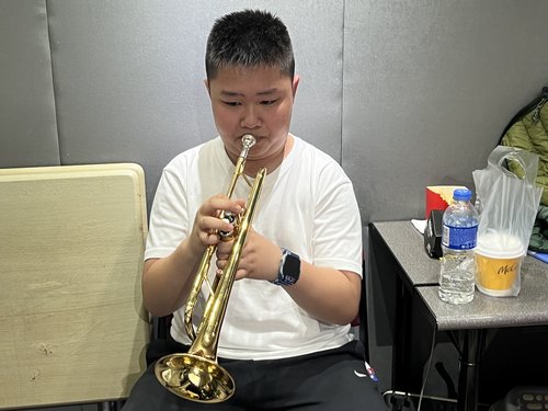 A student is practicing his trumpet, how wonderful it is for the concert!