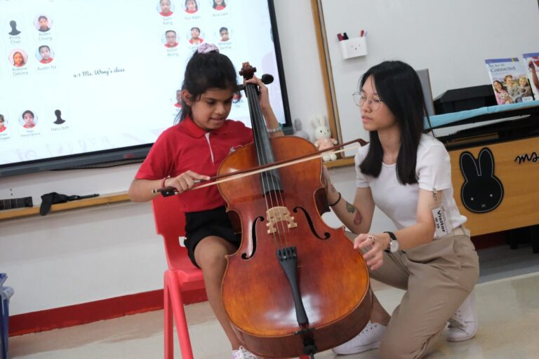 Pure Orchestral Centre instructor Sophie Ng is having a cello with one of her students.
